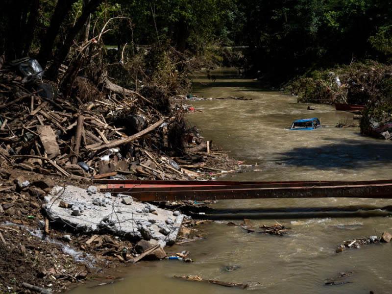 A partially submerged car in a creek near Hazard, Kentucky after the historic flooding in the summer of 2022. (Michael Swensen/Stringer via Getty Images North America)